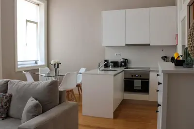 a living room with a couch and a kitchen at Magalhães Prime in Porto