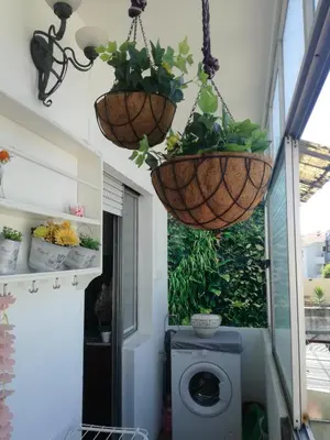 a bathroom with two hanging baskets and a washing machine at Art Gallery Apartment in Porto