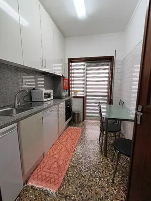 a kitchen with a sink and a table with chairs at Art Gallery Apartment in Porto