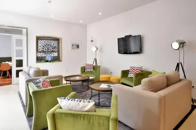 a living room with couches and a tv at Porto Domus Hotel in Porto