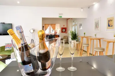 two bottles of champagne and two wine glasses on a counter at Porto Domus Hotel in Porto