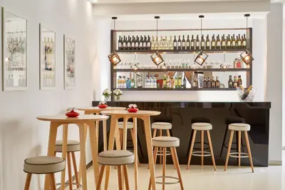 a bar with stools and a counter with drinks at Porto Domus Hotel in Porto