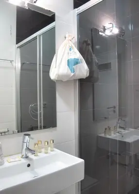 a bathroom with a sink and a mirror and a shower at Boavista Guest House in Porto