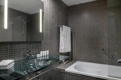 a bathroom with a tub and a sink and a mirror at AC Hotel Porto by Marriott in Porto