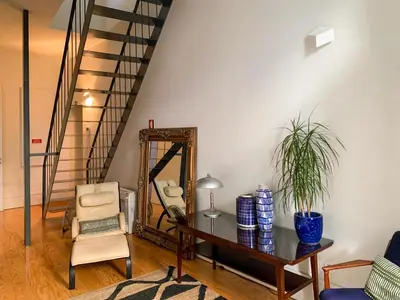 a living room with a mirror and a chair at Villa Lóios by Casa do Conto in Porto