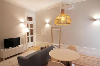 a living room with a table and a tv at Duque de Loulé in Porto