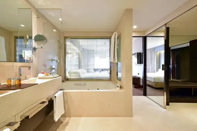 a bathroom with a tub and a large window at Porto Palácio Hotel by The Editory in Porto