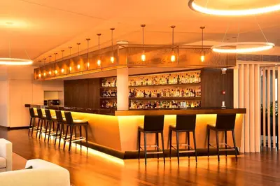 a bar in a restaurant with bar stools at Porto Palácio Hotel by The Editory in Porto