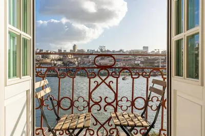 a balcony with a bench and a view of the water at YOUROPO - Ribeira Porto in Porto