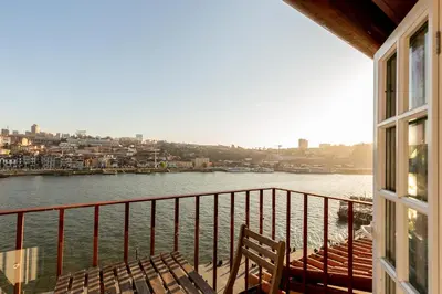 a balcony of a building with a view of the water at YOUROPO - Ribeira Porto in Porto