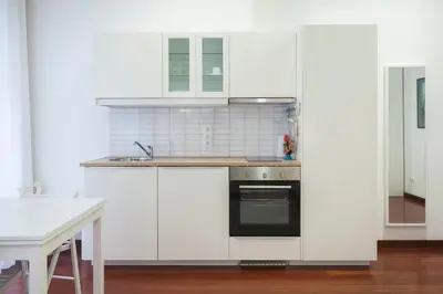 a kitchen with white cabinets and a sink at Flores Studio in Porto