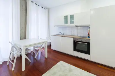 a kitchen with a white table and a white counter top at Flores Studio in Porto