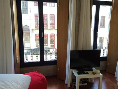 a bedroom with a bed and a television on a table at Flores Studio in Porto