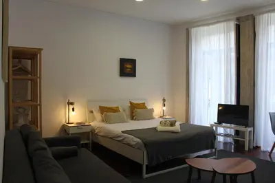 a bedroom with a bed and a living room at Flores Central in Porto