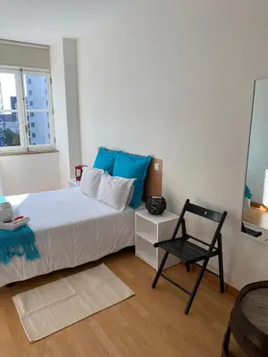 a bedroom with a bed and a chair in it at Formosa Oporto Apartments Group in Porto