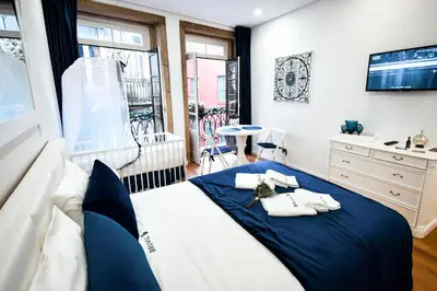 a bedroom with a blue and white bed and a window at Bruval Premium Apartments - Sé Porto in Porto
