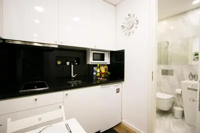 a white kitchen with white cabinets and a sink at Bruval Premium Apartments - Sé Porto in Porto