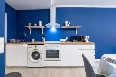 a blue kitchen with a washer and dryer at Ren Feb26 Clerigos Retreat in Porto