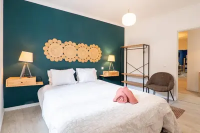 a bedroom with a large bed and a green wall at Ren Feb26 Clerigos Retreat in Porto
