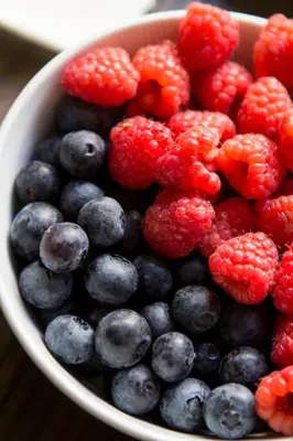 a bowl of berries and raspberries and blueberries at Gil Vicente - Charming Guesthouse in Porto