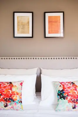 a bed with two pillows and two framed art at Gil Vicente - Charming Guesthouse in Porto