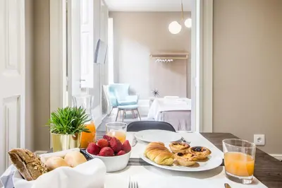 a table with plates of bread and fruit on it at Gil Vicente - Charming Guesthouse in Porto