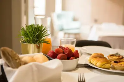 a table with plates of food and fruit on it at Gil Vicente - Charming Guesthouse in Porto
