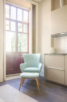 a blue chair in a kitchen with a window at Gil Vicente - Charming Guesthouse in Porto