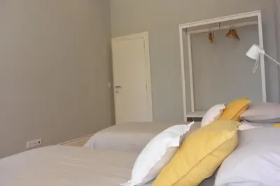 a bedroom with two beds with yellow and white pillows at Casa Paillard, by Flat in Porto in Porto