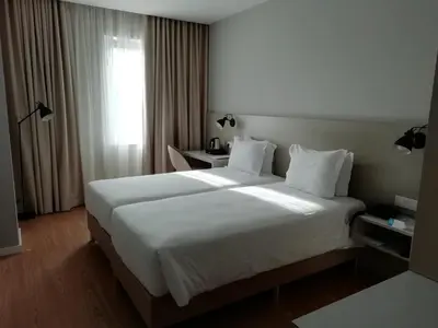 a hotel room with a large bed with white sheets at ClipHotel in Vila Nova de Gaia