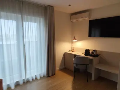 a room with a desk with a television and a window at ClipHotel in Vila Nova de Gaia