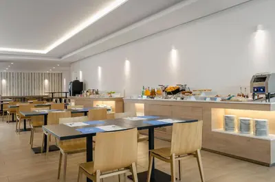 a restaurant with tables and chairs and a kitchen at ClipHotel in Vila Nova de Gaia