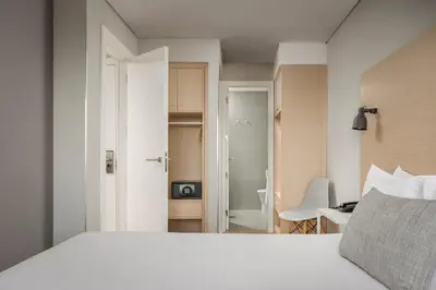 a bedroom with a white bed and a bathroom at ClipHotel in Vila Nova de Gaia