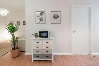 a room with a dresser with a microwave on it at GuestReady - Terracota Bureau in Porto