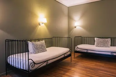 two beds in a room with lights on the wall at Hotel Sao Jose in Porto