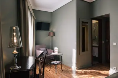 a living room with a chair and a lamp at Hotel Sao Jose in Porto