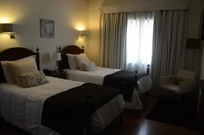 a hotel room with two beds and a window at Hotel Sao Jose in Porto