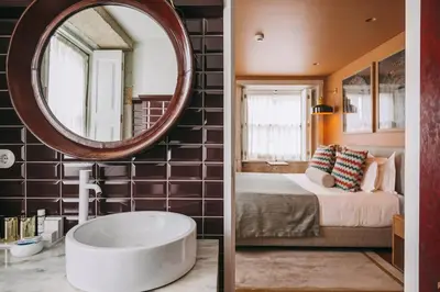 a bathroom with a large mirror and a bed and a tub at Gran Cruz House in Porto