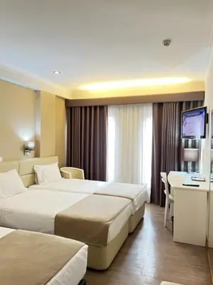 a hotel room with two beds and a desk at Seculo Hotel in Porto