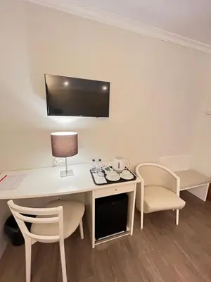 a room with a desk with a lamp and chairs at Seculo Hotel in Porto