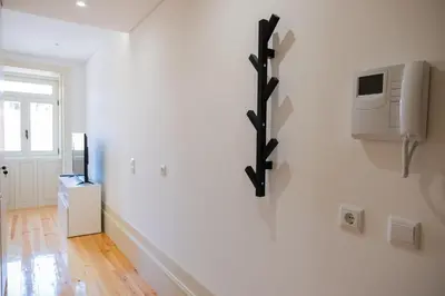 a white room with a tv on a wall at Lively Getaway Apartment in Porto
