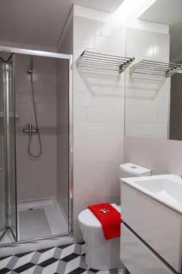 a bathroom with a shower and a toilet and a sink at Lively Getaway Apartment in Porto