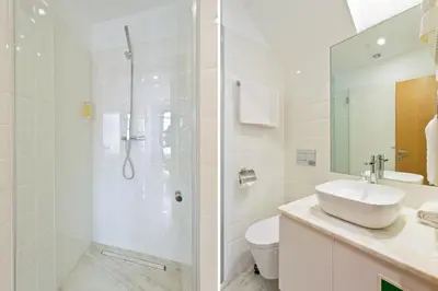 a white bathroom with a shower and a sink at OTF- Porto Centro in Porto