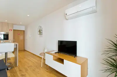 a living room with a flat screen tv on a white wall at OTF- Porto Centro in Porto