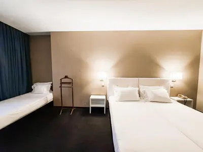 a room with two beds and a table and a chair at Stay Hotel Porto Centro Antas in Porto