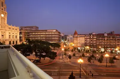 a city street at night with a clock tower at Vera Cruz Porto Downtown Hotel in Porto