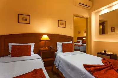 a hotel room with two beds and a mirror at Vera Cruz Porto Downtown Hotel in Porto