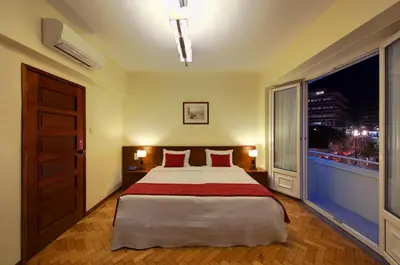 a bedroom with a bed with red pillows and a window at Vera Cruz Porto Downtown Hotel in Porto