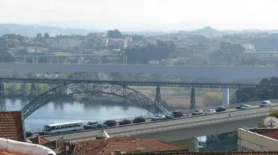 a bridge over a river with cars on it at Residencial Porto Novo - Alojamento Local in Porto