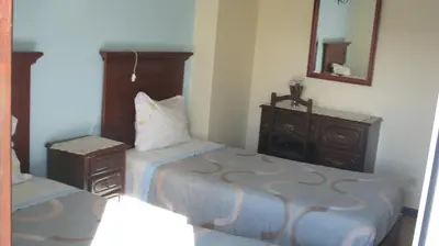 a bedroom with two beds and a dresser and a mirror at Residencial Porto Novo - Alojamento Local in Porto